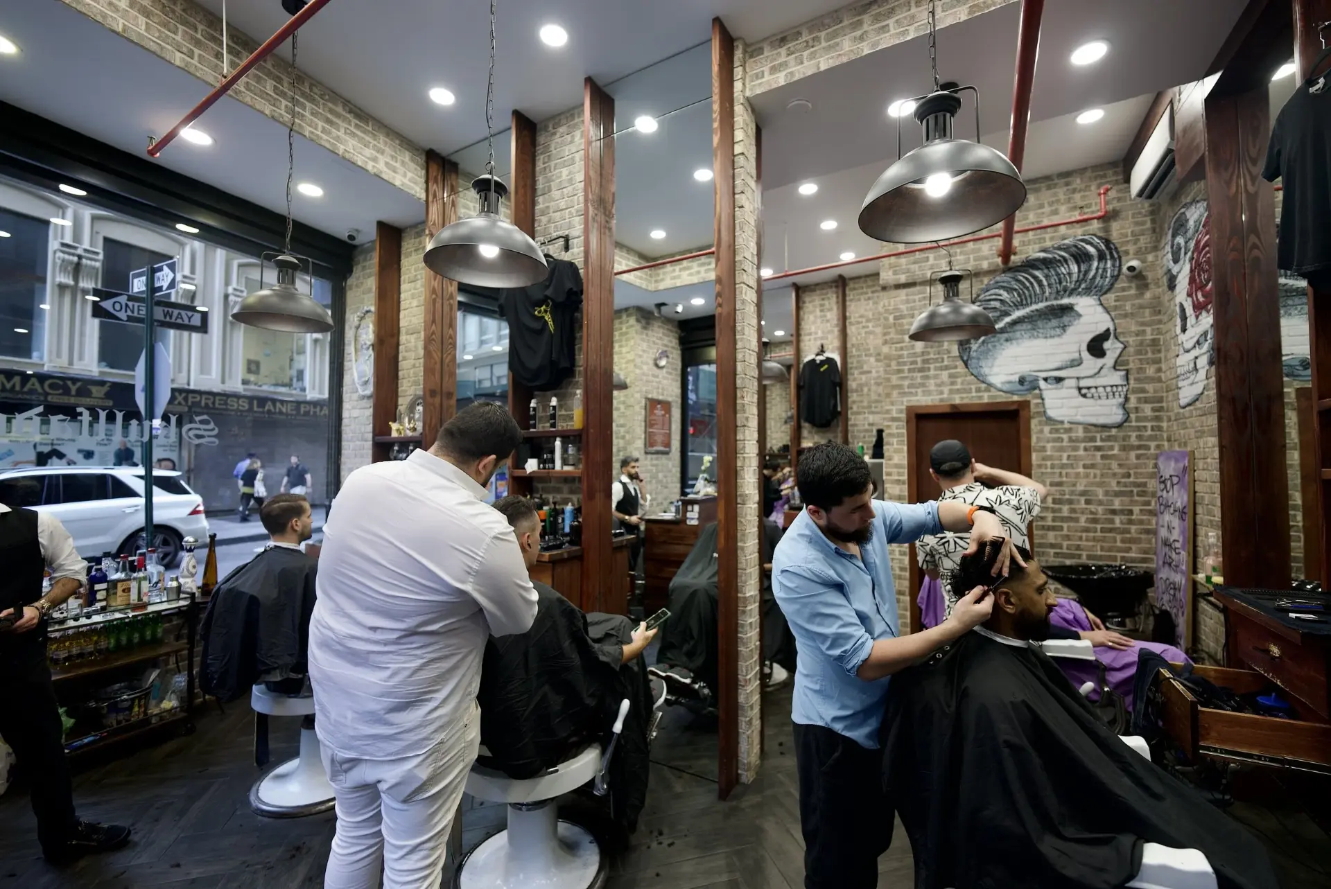 Barbers cutting hair inside Skullfade Barbers in NYC's Financial District
